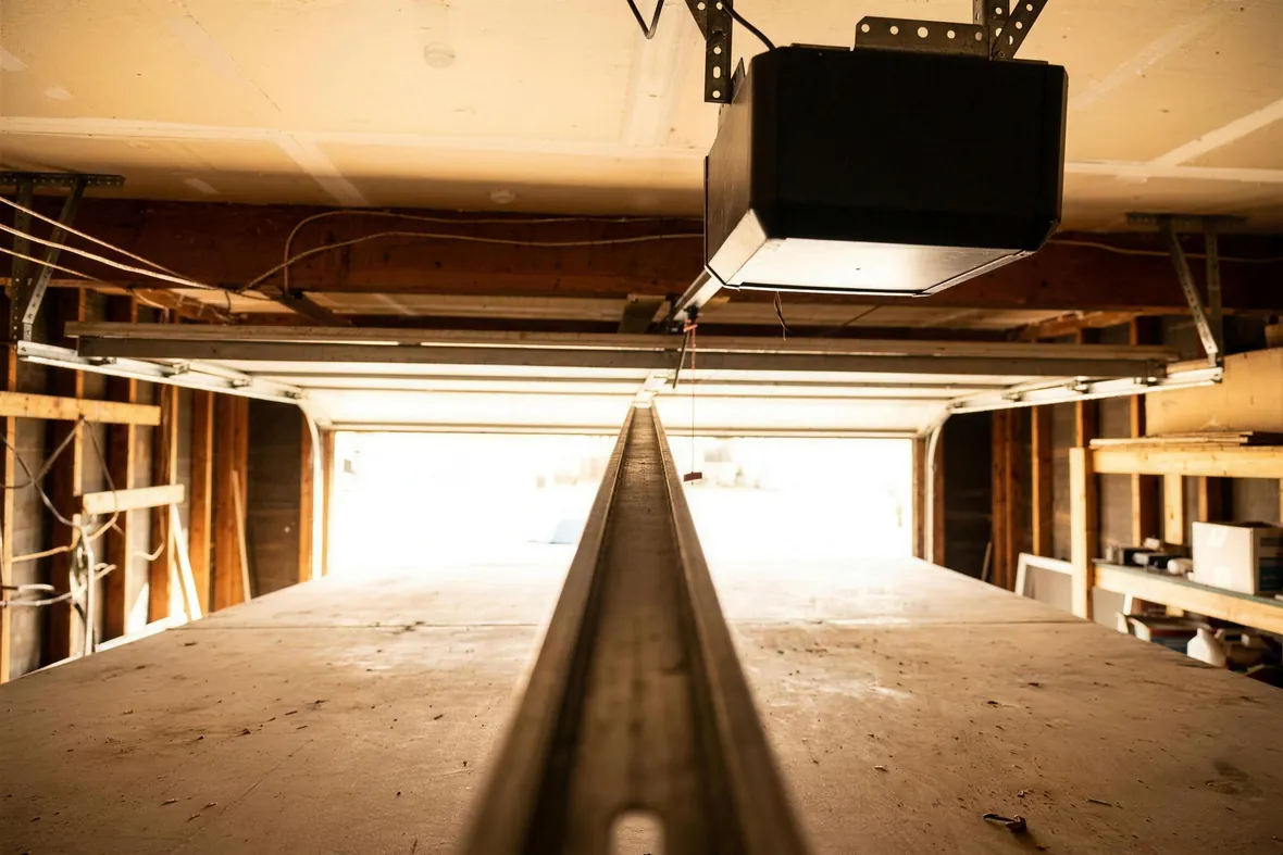The length of an opener rail seen from inside a garage, looking toward the motor head