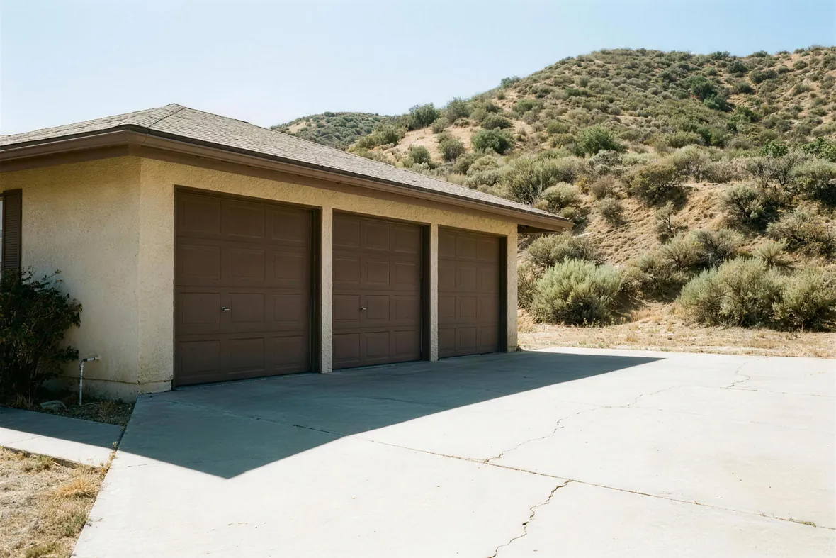 An attached three-car garage on a planned tract, in full afternoon sun